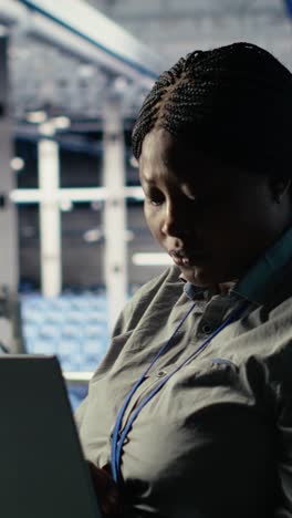 vertical video data center admin checks ai dashboard using laptop during rigs systems review
