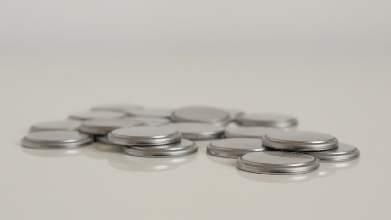 las baterías de las celdas derramadas en el video de inclinación 4k blanco