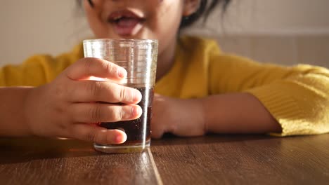 una chica joven disfrutando de un refresco.