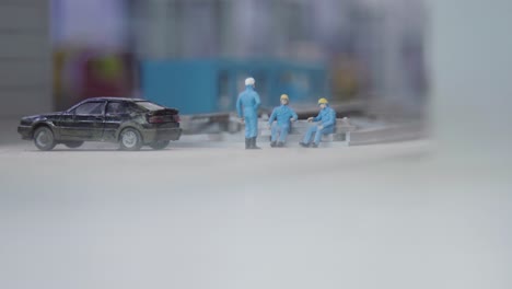 miniature city scene with workers and car