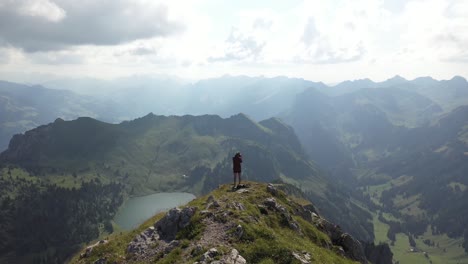 young man standing by himself alone, taking photos with his camera over the majestic, dramatic and amazing view