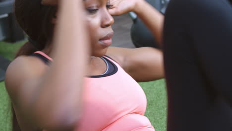 Young-woman-doing-side-crunches-in-a-gym,-close-up