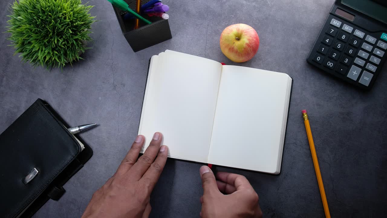 Open Notebook on a Desk with Various Items
