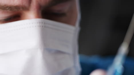 Male-healthcare-worker-preparing-syringe,-close-up