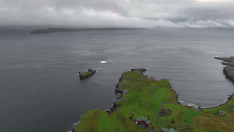 aerial flying over landscape on coast of torshavn, tilt up revealing stormy horizon. faroe islands