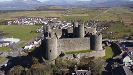 una vista aérea del castillo de harlech en un día soleado, volando de izquierda a derecha alrededor del castillo mientras se aleja, gwynedd, gales del norte, reino unido.