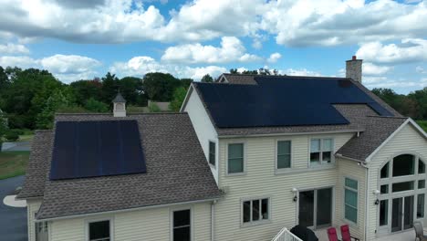 large house with solar panel arrays on shingle roof