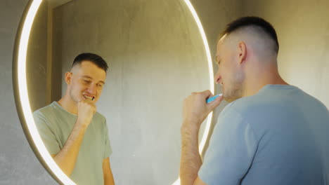 man brushing teeth in modern bathroom