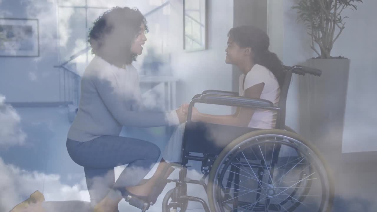 Animation of clouds over biracial mother with daughter in wheelchair