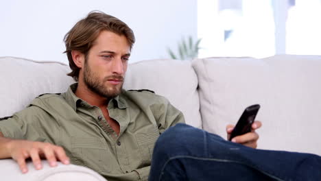 Attractive-man-watching-TV-and-holding-remote