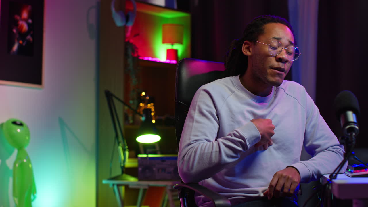 Man talking into a microphone in a studio setting