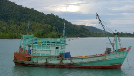 Eine-Statische-Aufnahme-Eines-Alten-Fischerbootes,-Das-In-Der-Nähe-Einer-Beschnittenen-Insel-Im-Meer-Verankert-Ist