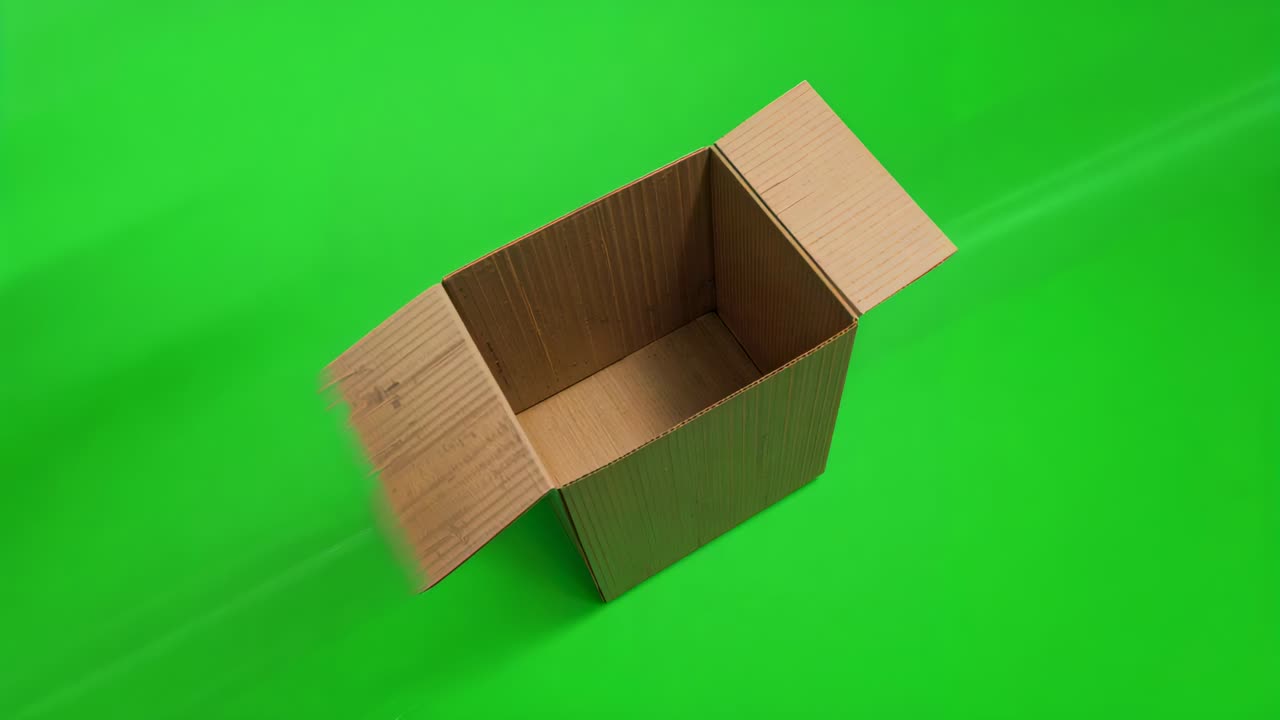 Panning camera circling cardboard box in studio on green chroma, revealing open flaps and interior