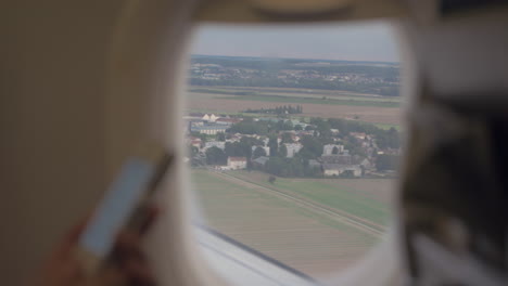 Frau-Mit-Handy-Und-Blick-Aus-Dem-Fliegenden-Flugzeug