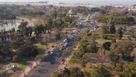 Aerial-drone-shot-of-bus-road-next-to-Bosques-de-Palermo-Park-and-River-Plate-in-backdrop