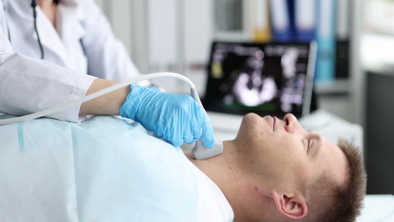 Doctor performing an ultrasound examination on a patient's neck
