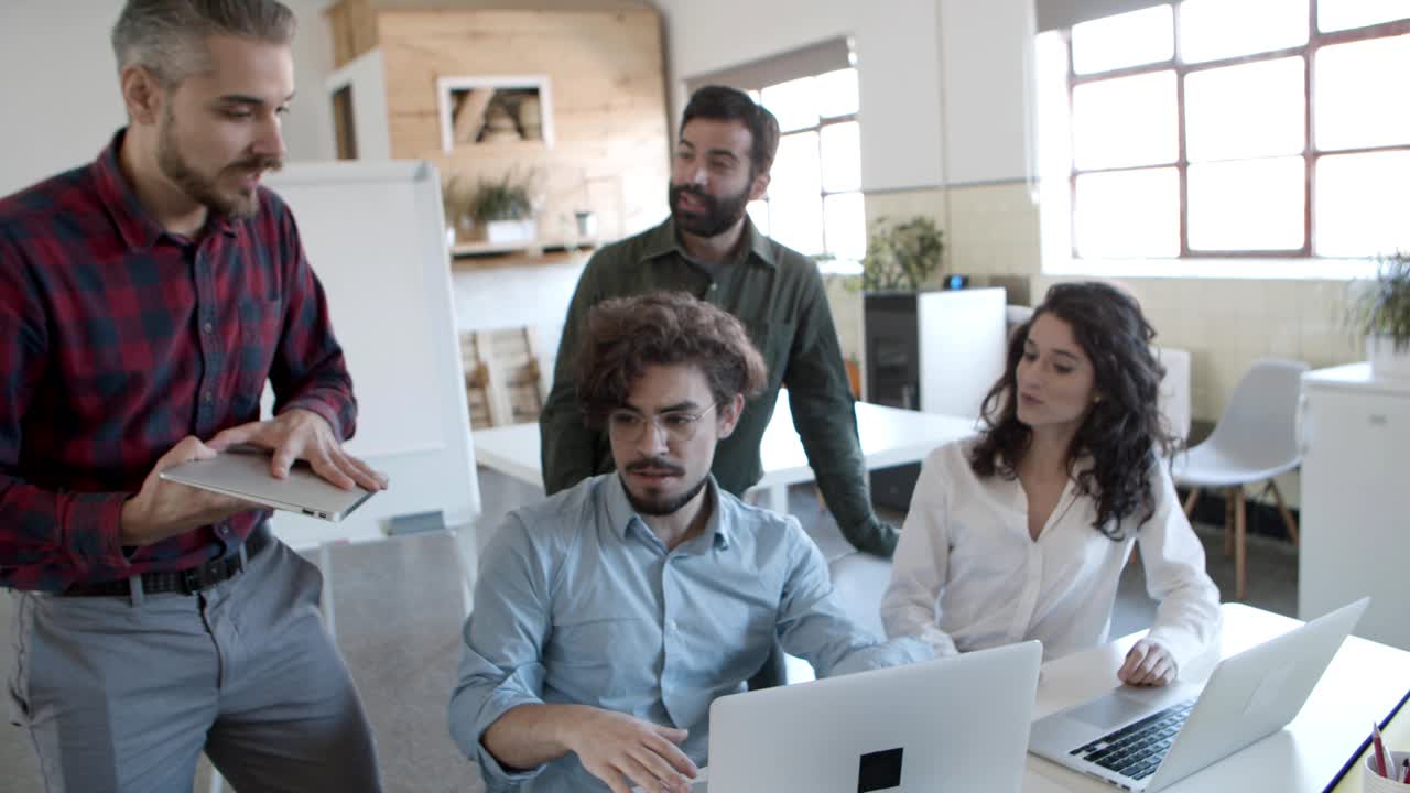 hombre barbudo y guapo caminando hacia colegas alegres y estrechando la mano