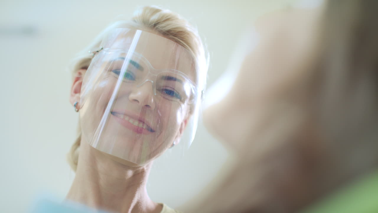 환자 의 치아 를 검사 하는 친절 한 의사. 여성 과 함께 일 하는 치과 의사