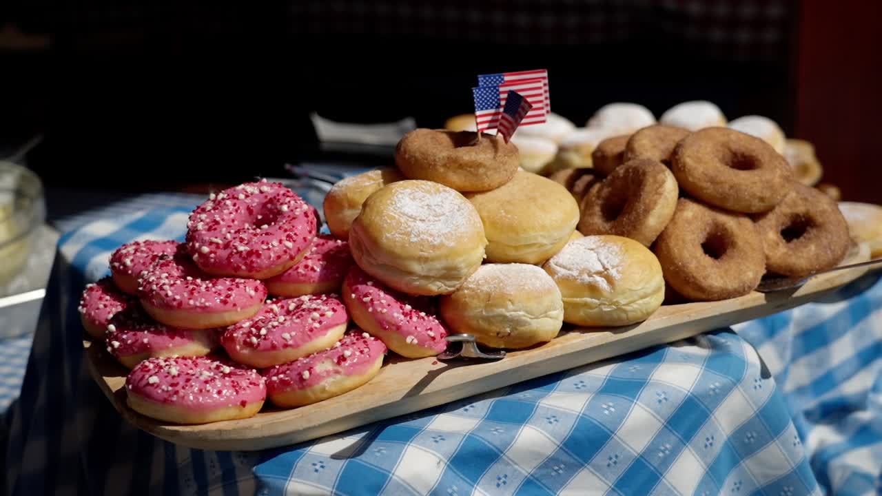 A tray of donuts and pastries on a checkered tablecloth