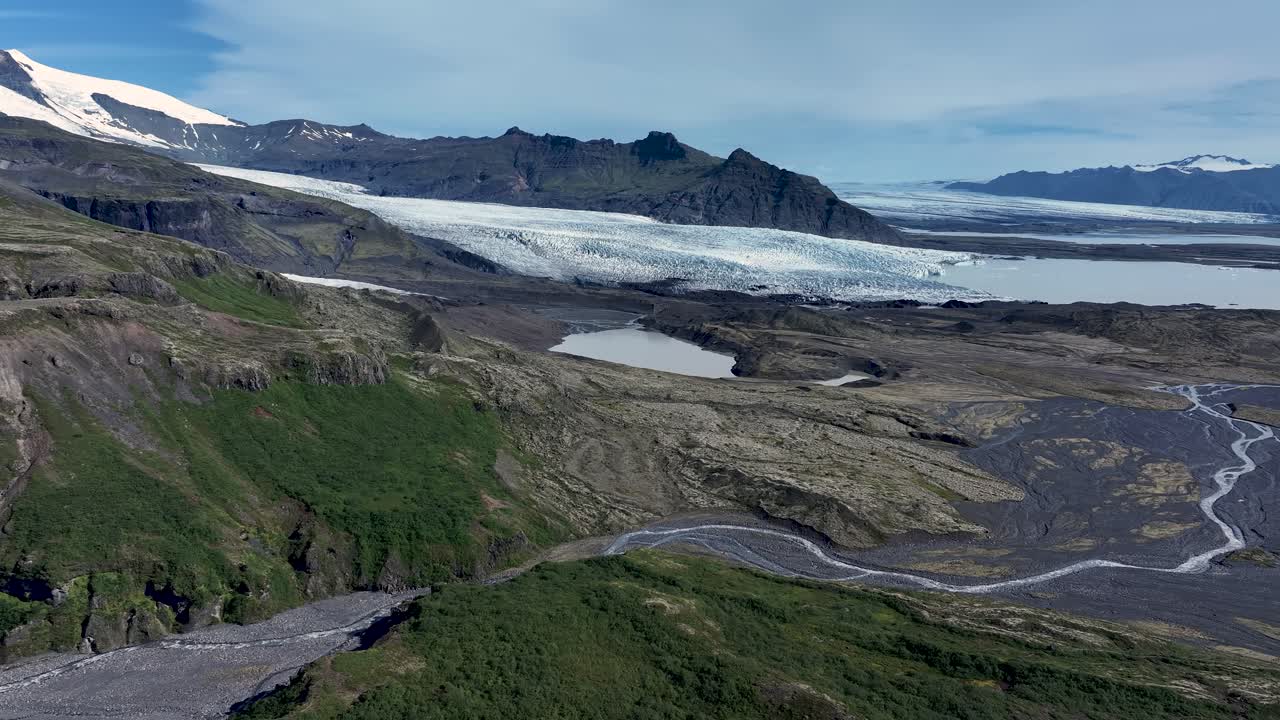 A breathtaking drone flight over Fjallsárjökull glacier and Fjallsárlón lagoon in Iceland, showcasing icy landscapes, rugged mountains, and dramatic glacial scenery