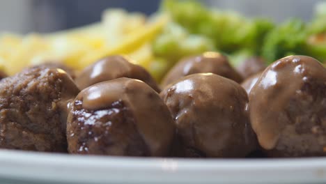 close-up of meatballs with gravy and sides