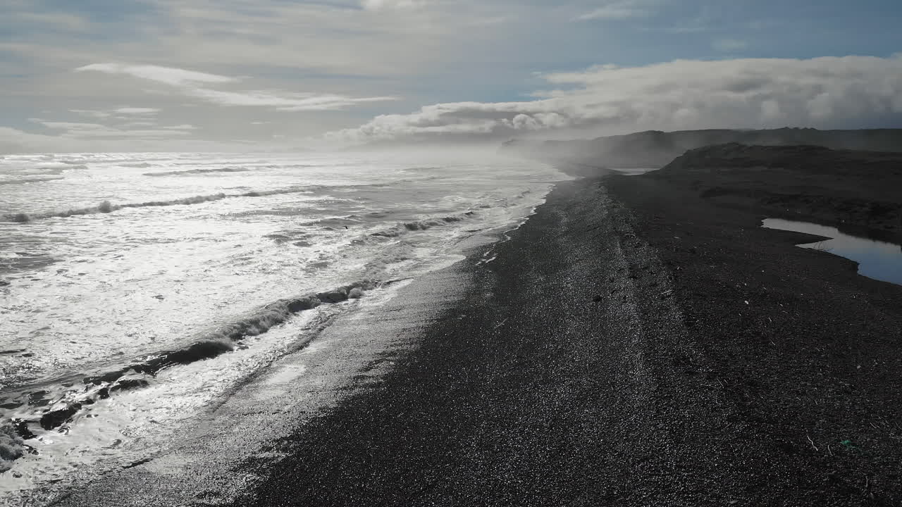 playa de arena negra con olas