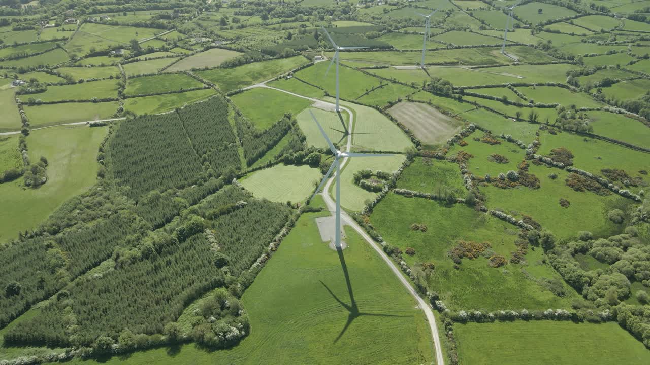 vista aérea de campos verdes, bosques y turbinas eólicas en la granja en verano