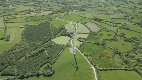 Vista-Aérea-De-Campos-Verdes,-Bosques-Y-Turbinas-Eólicas-En-La-Granja-En-Verano