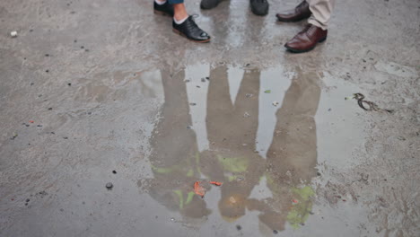 reflection in a puddle of feet and legs