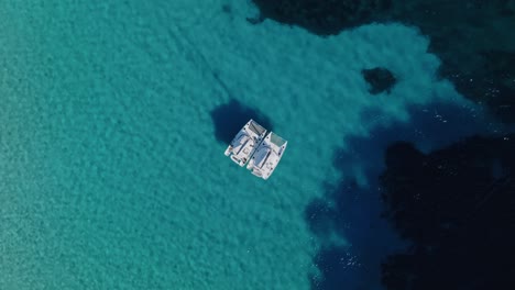 2 catamarans anchor alongside shallow reef in the mediterranean sea