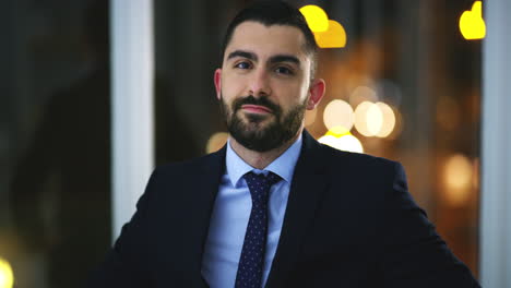 a young businessman standing in an office at night