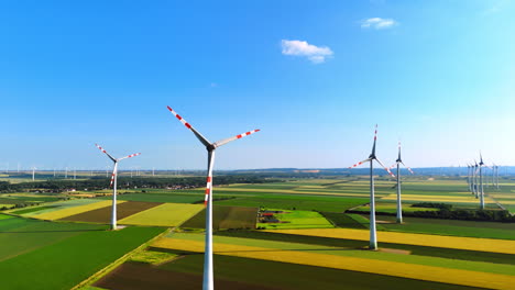 vast agricultural plantations with wind farms. beautiful blue sky with tiny clouds at backdrop. aerial view.