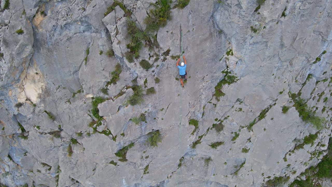 Top-down drone footage of a man top-rope climbing in the Pyrenees moutains at Tarascon sur Ari&egrave;ge