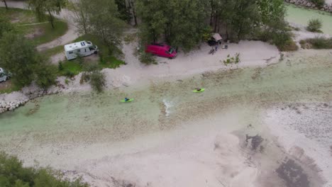 Slovenia-Soca-river-aerial-of-kayaking-people-passing-by-a-campsite,-drone-shot