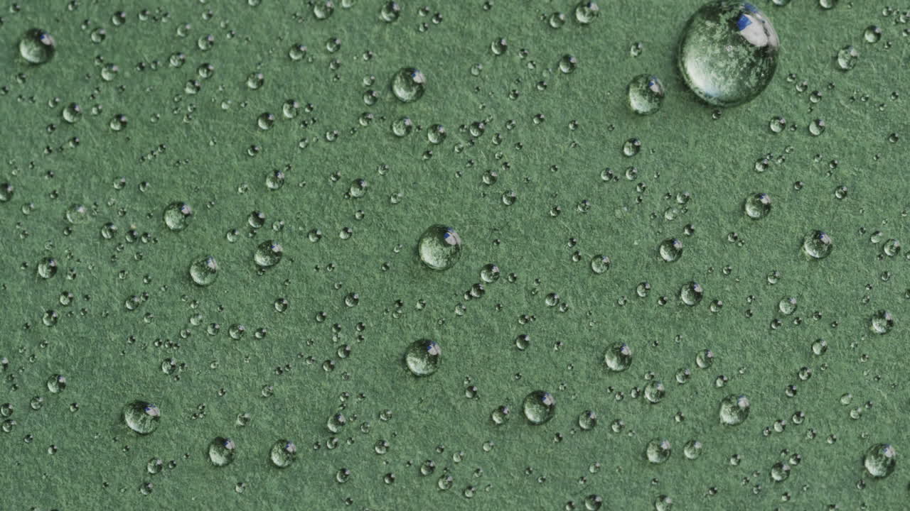 micro vídeo de primer plano de gotas de agua con espacio de copia en fondo verde