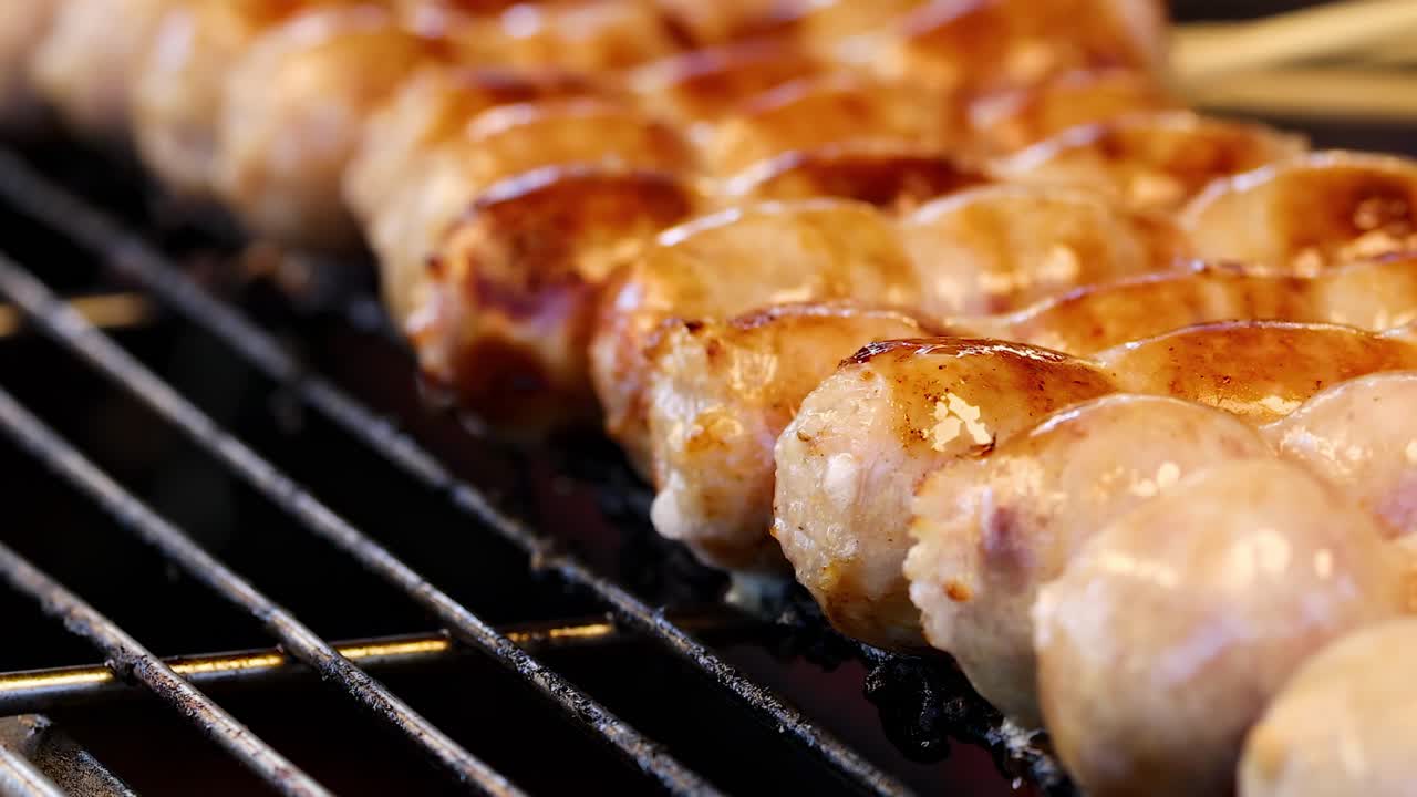 Sausages being grilled on skewers in Bangkok