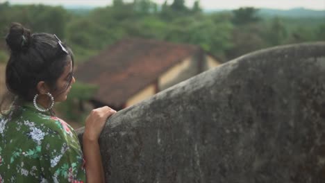 Dreamy-girl-looking-into-a-distance-over-a-concrete-wall