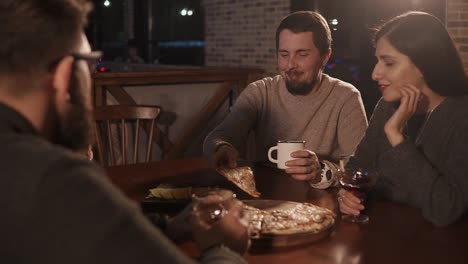 friends enjoying pizza and drinks at a restaurant