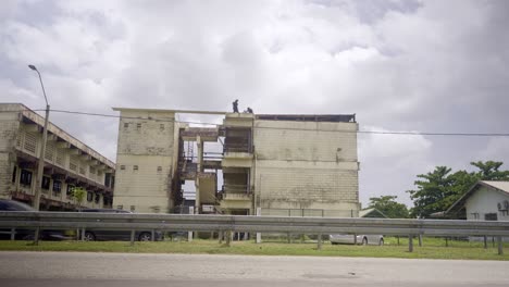 view from the street of natin school building in paramaribo suriname, cars driving by