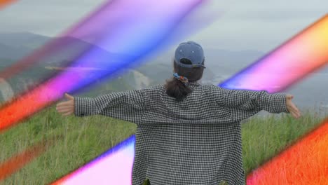 Woman with open arms surrounded by colorful energy rays