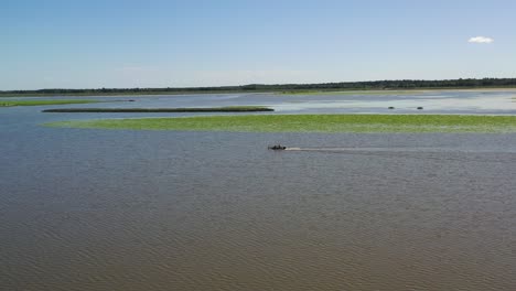 Alone-Boat-on-Sea-with-Reed,-Aerial-Backward