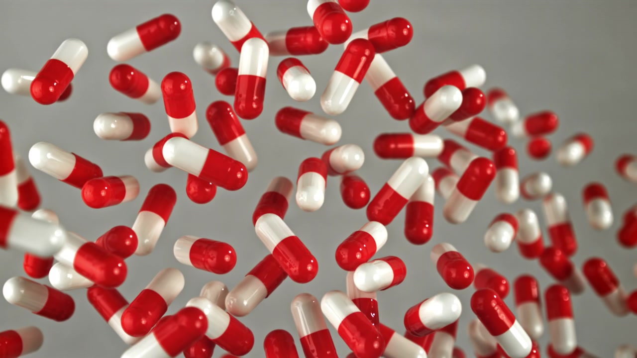 Capsule mediche rosse e bianche che cadono al rallentatore