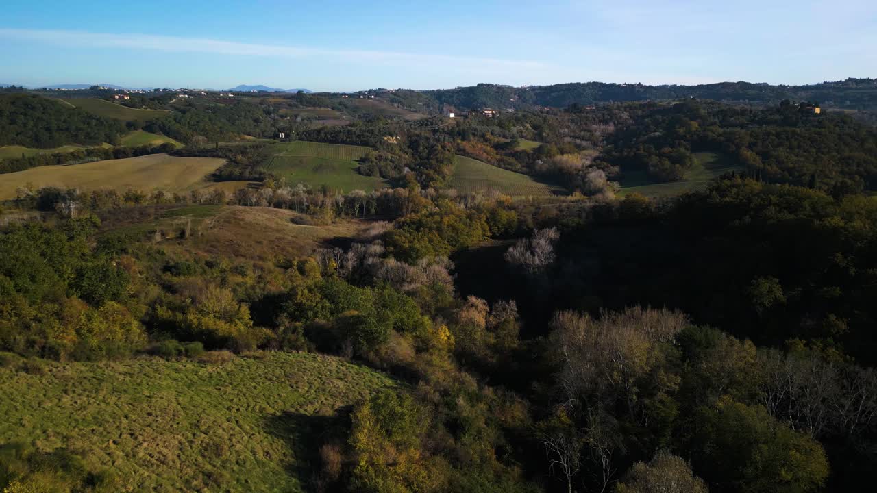 el dron desciende en el barranco del paisaje de huertos boscosos de la toscana en otoño
