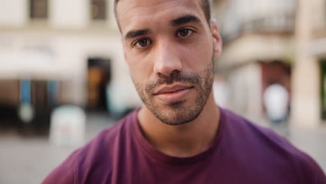 young man smiling at the camera outdoors.