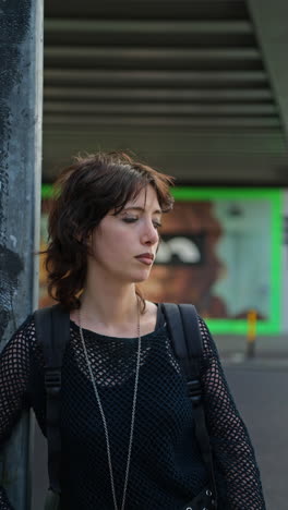 Vertical-Video-Outdoor-Fashion-Portrait-Of-Young-Alternative-Style-Woman-Standing-On-London-City-Street-Smoking-With-Road-In-Background