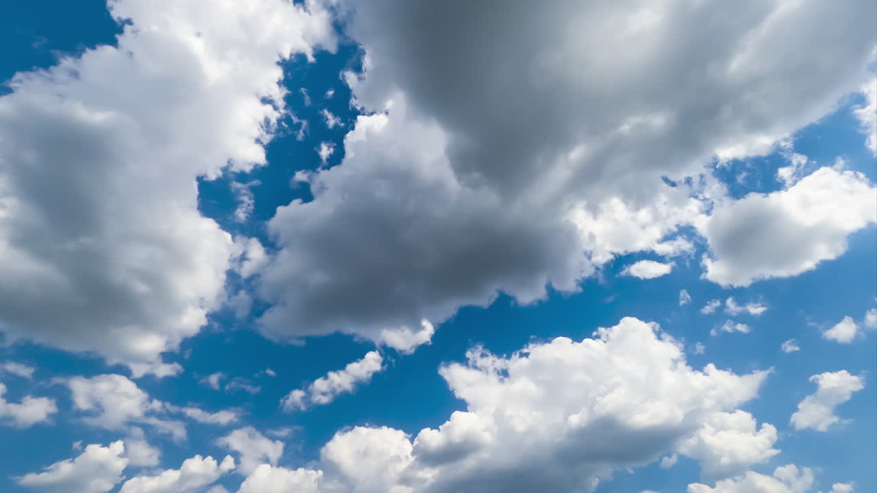 White fluffy cloudscape building in the sky. Clouds gathering in the summer skyline timelapse. Low angle perspective.