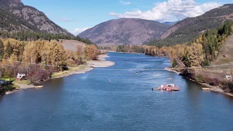 golden canopy: thompson river aerials with cable ferry and forested mountains in autumn