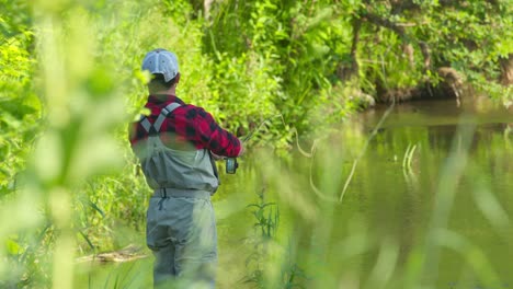 fly fishing. angler stands in the narrow river and casts the fly with fishing rod