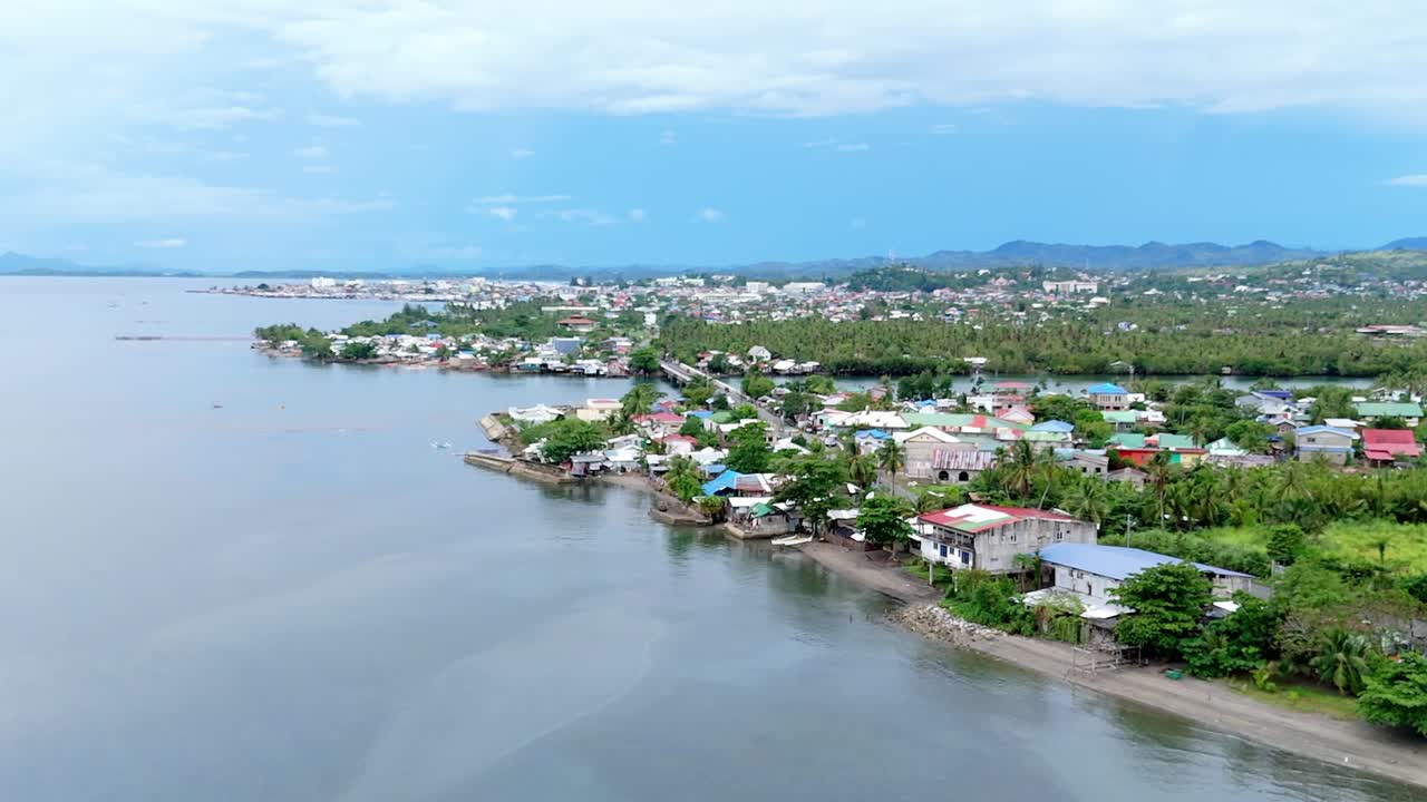 Surigao city coastline, overlooking lush greenery and buildings along the water, aerial view