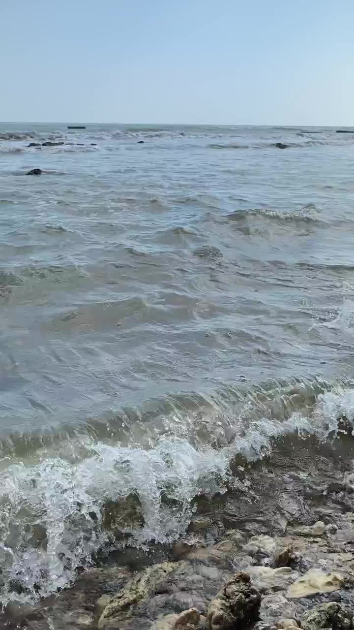 Onde dolci che si infrangono su una costa rocciosa.